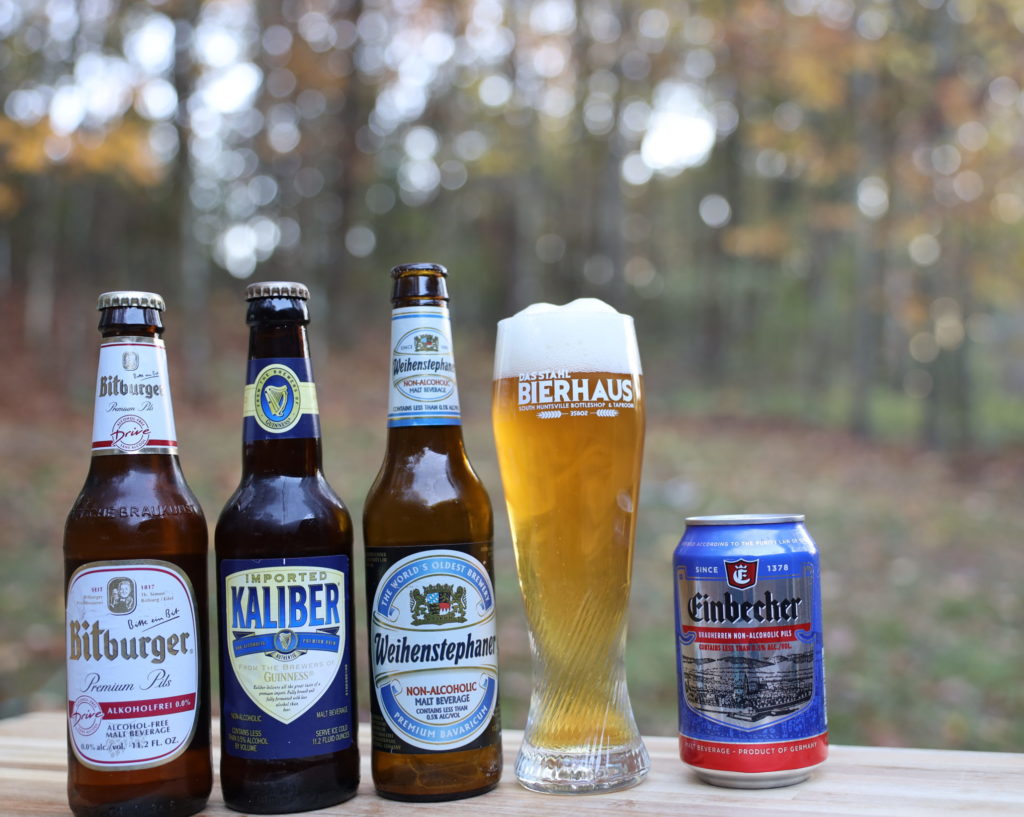 A lineup of four non-alcholic beers including Bitburger Pils, Guinness Kaliber, Weihenstephaner lager, and Einbecher Pils.